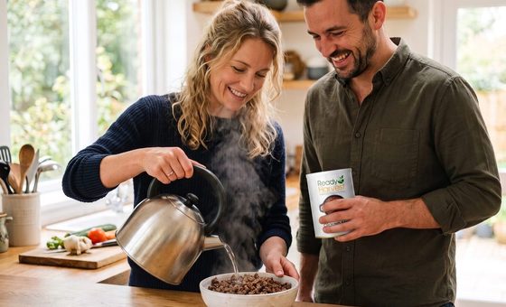 A husband and wife pouring hot water over freeze dried ground beef beside a Ready Harvest can